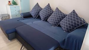 ein blaues Bett mit blauer Bettwäsche und Kissen darauf in der Unterkunft Apartment with sea view in Oropos
