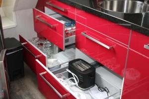 a kitchen with red cabinets and a sink at Hoeve Hofwijk in Kamperland