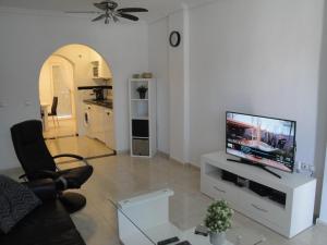 ein Wohnzimmer mit einem TV in einem weißen Unterhaltungszentrum in der Unterkunft Ground floor apartment Torrevieja Spain in Orihuela