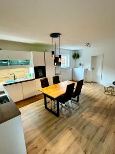 a kitchen and dining room with a wooden table and chairs at Adenauer Forst Ring Apartment in Adenau