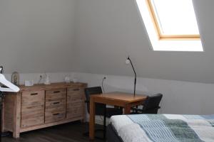 a bedroom with a table and a bed and a desk at Hoeve Hofwijk in Kamperland