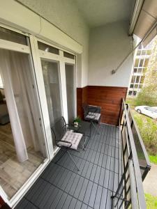 un balcone con 2 sedie e un grill su una casa di Janka11 Apartman a Hódmezővásárhely