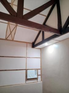 a room with white walls and a ceiling with beams at Banamboo in Badian