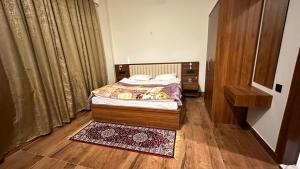 a bedroom with a bed and a wooden floor at Fourseasonkasauli in Solan