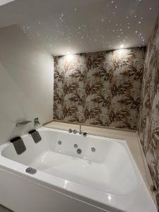 een wit bad in een badkamer met een muur bij La Casa Di Eva in Siracusa