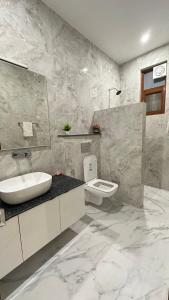 Un baño blanco con lavabo e inodoro. en F s kasauli, en Solan