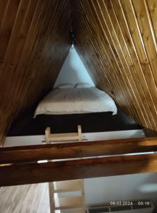 a bed in a room with a wooden ceiling at Cabana NucA-Frame in Satu Nou de Jos