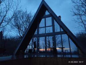 una ventana de una casa con una puesta de sol vista a través de ella en Cabana NucA-Frame en Satu Nou de Jos