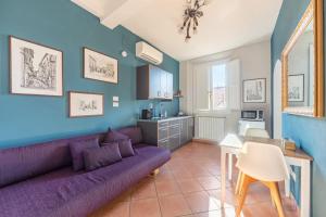 ボローニャにあるSan Giorgio Apartmentの紫色のソファ付きのリビングルーム、キッチンが備わります。