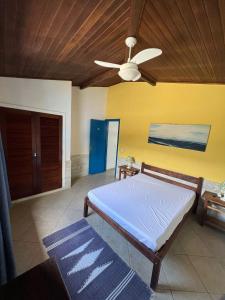 a bedroom with a bed and a ceiling fan at Linda Casa em Búzios in Búzios
