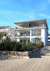 ein großes weißes Gebäude mit vielen Fenstern in der Unterkunft MAISON AMAND - Am See mit Privatstrand in Immenstaad am Bodensee