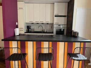 een keuken met een aanrecht met drie stoelen bij Une escapade au cœur de Tours in Tours