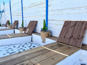 2 sillas de madera sentadas en un porche con cactus en Villa les cigales - Paisible avec piscine en Mas-Saintes-Puelles