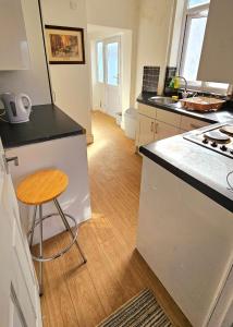 a kitchen with a counter and a stool in it at Wolves Living in Bushbury