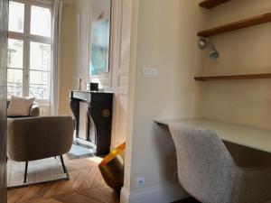 een kamer met een bureau, een stoel en een open haard bij Une escapade au cœur de Tours in Tours