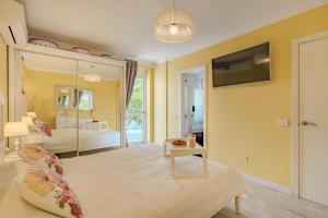 sala de estar amarilla con cama y TV en BuenaVista Romantic Bungalow in Costa Adeje, en Adeje