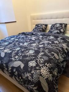 a bed with a black and white blanket and pillows at L’ Appart Renaissance in Bar-le-Duc