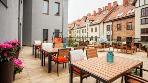 a patio with tables and chairs and buildings at Apartamenty Bałtyckie - Grand Baltic - WIFI, Klimatyzacja, Sala Zabaw, Taras wypoczynkowy, centrum Ustki in Ustka