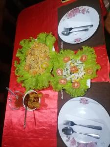 einen Tisch mit Teller mit Lebensmitteln darüber in der Unterkunft Ella Shali's home in Ella