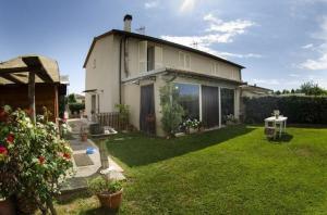 una casa con un giardino con erba verde e una casa di Ferienhaus für 5 Personen ca 125 qm in Lucca, Toskana Provinz Lucca a Lucca