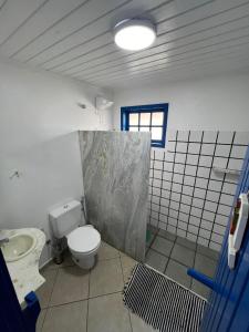 a bathroom with a toilet and a sink at Linda Casa em Búzios in Búzios