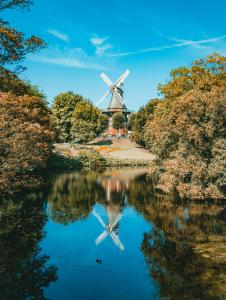 a windmill reflected in the water of a river at Zentrale Wohnung fußläufig zu Weser und Innenstadt in Bremen