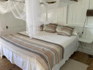 una camera con letto bianco e zanzariera di VILLA MADERA DEL SOL --- Playa Las Ballenas a Las Terrenas