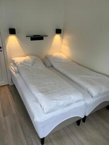 un grande letto bianco con luci sul muro di Finsnes Gaard a Finnsnes