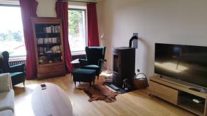 uma sala de estar com uma televisão e duas cadeiras e uma mesa em Chez Niréas & Serge em Blavozy