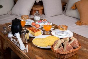 a coffee table with plates of bread and eggs on it at Riad MISS CARACAL Jacuzzi & Rooftop in Marrakesh