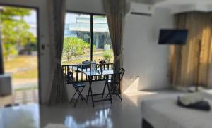 a table and chairs in a room with a window at Siri Maya Garden Home Samui in Koh Samui 
