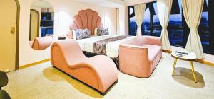 a bedroom with a bed and a couch and chairs at Hotel Nova Bling in Rajkot