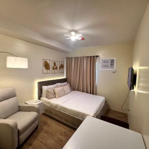 - une petite chambre avec un lit et un canapé dans l'établissement Condo near Nuvali Laguna Technopark St Benedict Church, à Bayabasan