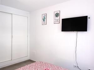 a bedroom with a bed and a flat screen tv at Paradise Palms I Deluxe, incl. Welcome Package in Corralejo