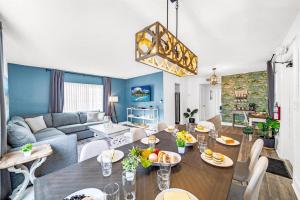 a living room with a table and a couch at Palm Wave Stays - Designer's Stay - Sleeps 10 in Coconut Creek