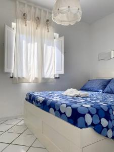 a bedroom with a blue and white bed and a chandelier at Dolcevita Villa in Vulcano in Vulcano