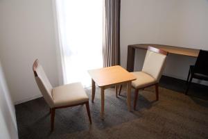 2 Stühle und ein Tisch in einem Zimmer in der Unterkunft Ginza International Hotel in Tokio