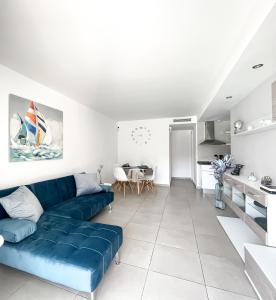 a living room with a blue couch and a kitchen at Paradise Palms I Deluxe, incl. Welcome Package in Corralejo
