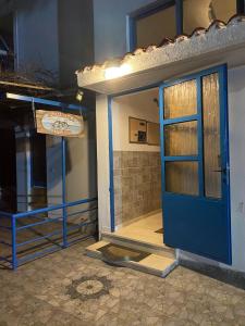 uma casa com uma porta azul num quarto em Alexandra Studios em Neos Pirgos