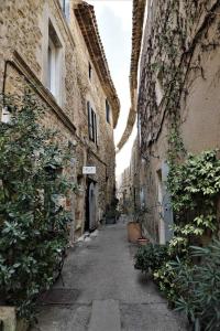 an alley between two buildings in an old town at Maison La Plaine in Lourmarin