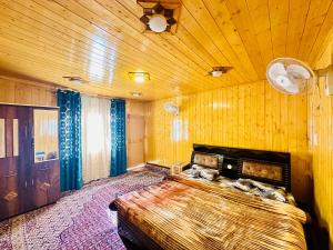 a bedroom with a large bed with a wooden ceiling at Houseboat New world in Srinagar