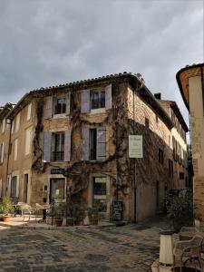 an old stone building with a table in front of it at Maison La Plaine in Lourmarin