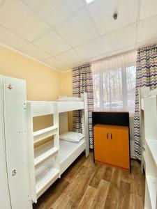 Cette chambre comprend 2 lits superposés et une fenêtre. dans l'établissement Alma-Ata Hostel, à Almaty