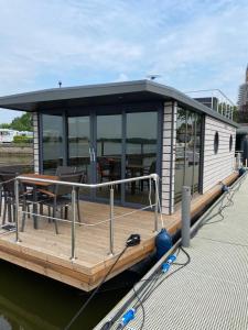 a house boat on the water with a dock at Hausboot Claudia Schleswig in Schleswig