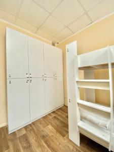 um quarto com armários brancos e um beliche em Alma-Ata Hostel em Almaty