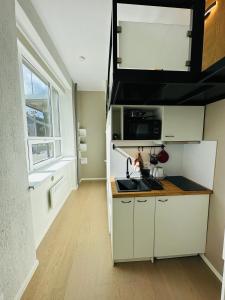 a kitchen with white cabinets and a sink and a window at City Apartments in Tallinn