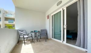 a room with a balcony with a table and chairs at Paradise Palms I Deluxe, incl. Welcome Package in Corralejo