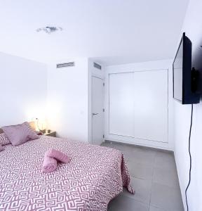a bedroom with a bed and a flat screen tv at Paradise Palms I Deluxe, incl. Welcome Package in Corralejo
