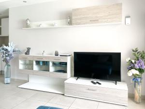 a white entertainment center with a flat screen tv at Paradise Palms I Deluxe, incl. Welcome Package in Corralejo