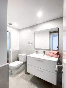 a bathroom with a toilet and a sink and a mirror at Paradise Palms I Deluxe, incl. Welcome Package in Corralejo